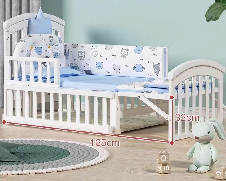 White crib with blue bedding and measurements on a wooden floor.